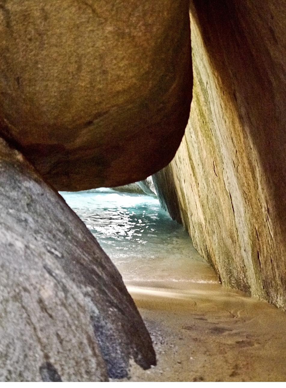Motion — ocean waves seen through a passage of boulders